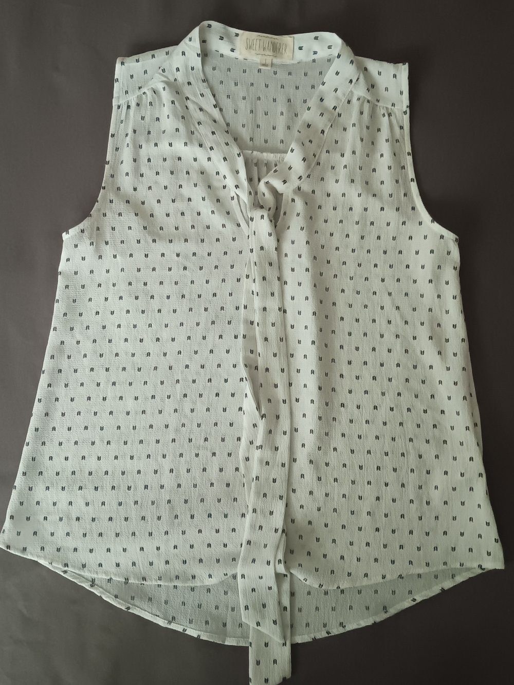 Sweet Wanderer Cream Sleeveless Tie-Neck Blouse with Black Micro Designs,